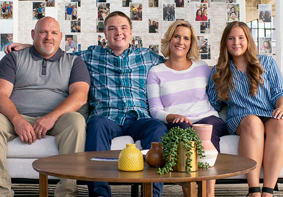 AdoptUSKids spokesfamily, the Thompsons sitting on a sofa